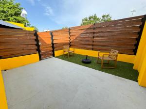 un patio trasero con 2 sillas y una valla en Villas at Auxilio Mutuo 103, en San Juan