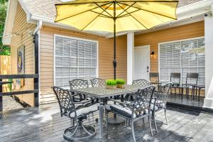 a table with chairs and an umbrella on a deck at Colorful Baton Rouge Home Deck, Grill and Fire Pit in Baton Rouge