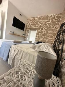 a bedroom with a bed and a stone wall at Crispi Guest House MMG in Olbia
