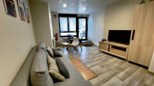 a living room with a couch and a television at Lapaserina-A in Arenas de Cabrales