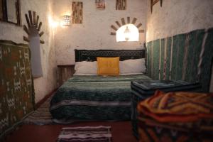 Schlafzimmer mit einem Bett mit orangefarbenem Kissen in der Unterkunft Traditional house in Marrakesch
