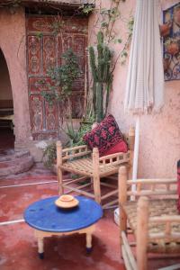 eine Terrasse mit einer Bank, einem Tisch und einem Sonnenschirm in der Unterkunft Traditional house in Marrakesch