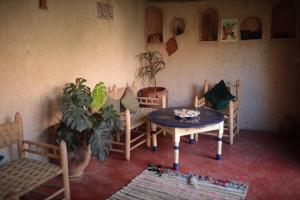 ein Zimmer mit einem Tisch und Stühlen sowie einer Topfpflanze in der Unterkunft Traditional house in Marrakesch