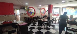 two people standing in a restaurant with a table and chairs at hotel interamericano in Barranquilla