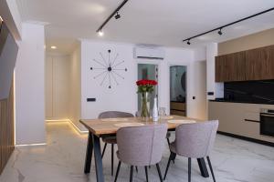 a dining room with a table and chairs and a clock at Apartment PREMIUM CALPE in Ifach