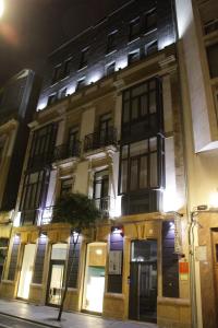 a building on a city street at night at Apartamentos Capua in Gijón