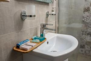 a bathroom sink with a tray of toiletries on it at Agmashenebeli Lilu's Apartment 2 in Tbilisi City +14 photos