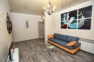 a living room with a blue couch and a painting at Agmashenebeli Lilu's Apartment 2 in Tbilisi City