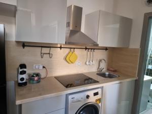 a kitchen with a sink and a washing machine at Camelgila Appartment Royal Residence in Port Ghalib