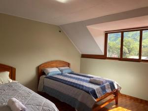 a bedroom with two beds and a window at LagunaNegra Oxapampa in Palmira +22 photos