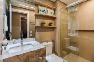 a bathroom with a toilet and a sink and a shower at DLH - Apartamentos no Coração de Gramado Próximos à Rua Coberta in Gramado +184 photos