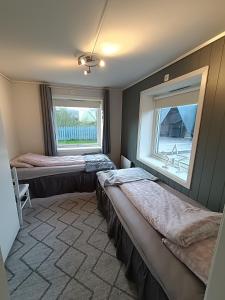 a bedroom with two beds and a window at 3-roms leilighet, innsjekk uten vert. Egen inngang in Ålesund