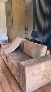 a large couch sitting on the floor in a room at Studio Central Todo Planejado com Ar Condicionado in Bagé