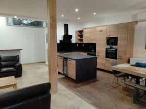a large kitchen with a black island in a living room at La casa de Soto in Lourdes
