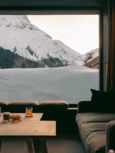 a living room with a view of a snow covered mountain at Hotel Schwarzwand in Lech am Arlberg