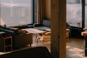 a living room with couches and a large window at Hotel Schwarzwand in Lech am Arlberg
