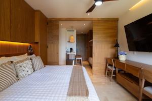 a bedroom with a bed and a flat screen tv at Beachfront|Pool|Gym Beautiful Studio Zantamar 303D in Cruz de Huanacaxtle