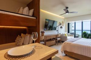 a bedroom with a bed and a table with a wine glass at Beachfront|Pool|Gym Beautiful Studio Zantamar 303D in Cruz de Huanacaxtle +10 photos