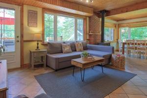 a living room with a blue couch and a table at Chalet du Domaine Spa privé et lac in Saint Adolphe D'Howard +38 photos