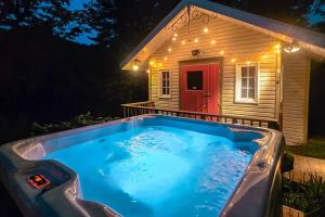 a hot tub in front of a house at night at Chalet du Domaine Spa privé et lac in Saint Adolphe D'Howard