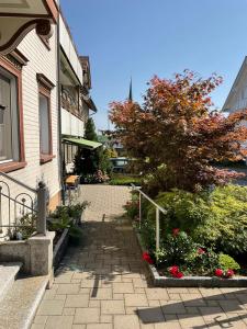 a brick walkway leading to a house with flowers at 22 - Gästehaus Erika - Hundwil - Appenzellerland in Hundwil +13 photos