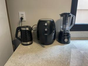 three appliances sitting on a counter next to a window at Studio Central Todo Planejado com Ar Condicionado in Bagé
