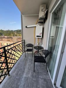 a balcony with two chairs and a table on a building at Sunset Sea View Apartment Green Cape Batumi in Batumi