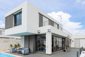una casa blanca con una piscina delante de ella en Dialez Holidays - Villarenys, en Arenys de Mar