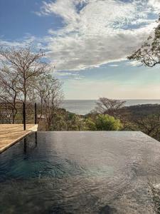 a swimming pool with a view of the ocean at Casa Deriva - Modern 3 Bedroom AC with Pool in Playa Maderas