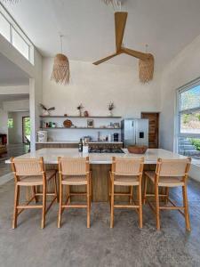 a kitchen with a table and chairs and a counter at Casa Deriva - Modern 3 Bedroom AC with Pool in Playa Maderas