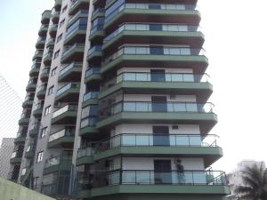 a tall apartment building with balconies at Apartamento Vereda Tropical in Guarujá