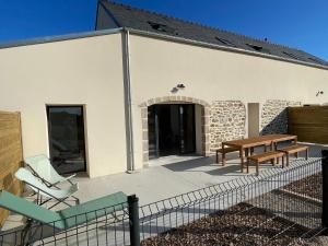 a patio with a table and chairs in front of a building at Les Gîtes De Roma in Plogonnec