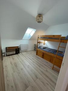 a bedroom with two bunk beds and a wooden floor at Les Gîtes De Roma in Plogonnec