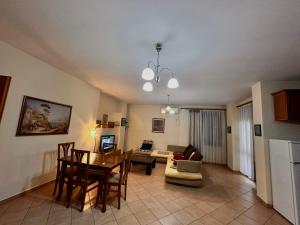Una sala de estar con una mesa y un comedor. en Grande House, en Tirana