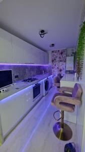 a kitchen with white cabinets and a chair in a room at Laura House in Simeria
