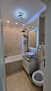 a bathroom with a sink and a toilet and a tub at Laura House in Simeria