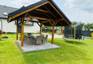 a pavilion with chairs and a table in a yard at Noclegi DobraNocka in Sąpów
