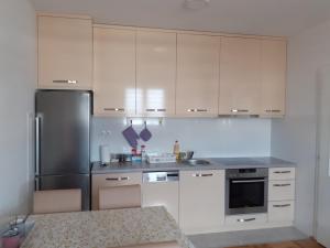 a kitchen with white cabinets and a stainless steel refrigerator at IVANA in Bijeljina