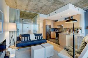 ein Wohnzimmer mit einem blauen Sofa und einer Küche in der Unterkunft Les Immeubles Charlevoix - Le 760214 in Québec