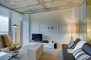 ein Wohnzimmer mit einem Sofa und einem Stuhl in der Unterkunft Les Immeubles Charlevoix - Le 760214 in Québec