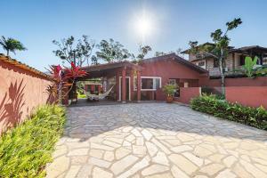 a house with a stone driveway in front of it at 4 dorm com piscina a 350 m de Camburizinho in Camburi