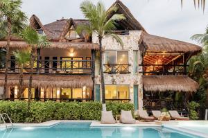 a villa with a swimming pool and a resort at Casa de Los Vientos Soliman Bay in Tulum