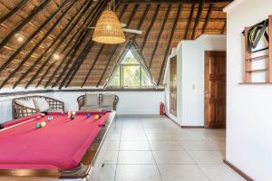 a ping pong table in a room with a ceiling at Casa de Los Vientos Soliman Bay in Tulum