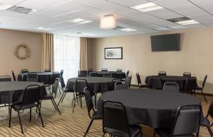 a room with tables and chairs and a tv at Comfort Suites Hartville-North Canton in Uniontown