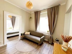 een woonkamer met een bank en een raam bij Stillvolle Stadtwohnung am Klinikum Bielefeld, zentral und mit Parkplatz! in Bielefeld
