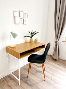 een bureau met een zwarte stoel en een lamp bij Stillvolle Stadtwohnung am Klinikum Bielefeld, zentral und mit Parkplatz! in Bielefeld +9 foto's