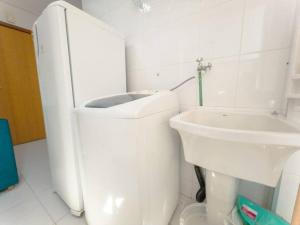 a white bathroom with a toilet and a sink at Apartamento Ar Cond Wi-Fi UEM Smart - DG603 in Maringá
