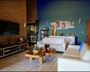 ein Wohnzimmer mit weißen Sofas und einem Fernseher in der Unterkunft Casa de Praia I Alagoas I Nordeste-Coruripe in Coruripe