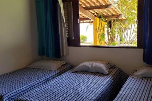 zwei Einzelbetten in einem Schlafzimmer mit Fenster in der Unterkunft Casa de Praia I Alagoas I Nordeste-Coruripe in Coruripe + 12 Fotos