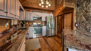 een keuken met witte kasten en een stenen muur bij Knotty By Nature in Blue Ridge